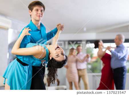 Teaching latin american dances in dance studio - people of different ages dance in pairs Teaching latin american dances in dance studio - people of different ages dance in pairs 137023547