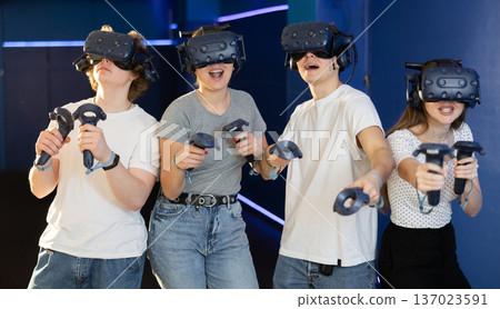 Group of excited young people playng virtual game Group of excited young people playng virtual game 137023591