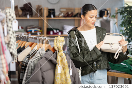 Asian woman browsing goods items and choose elect ladys bag Asian woman browsing goods items and choose elect ladys bag 137023691