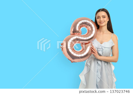 Young woman smiles with a large balloon shaped like 8 Young woman smiles with a large balloon shaped like 8 137023746