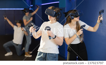 Portrait of young woman with virtual reality glasses standing in room Portrait of young woman with virtual reality glasses standing in room 137023797