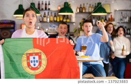Fans with the flag of Portugal celebrate the victory of their favorite team in beer bar Fans with the flag of Portugal celebrate the victory of their favorite team in beer bar 137023883