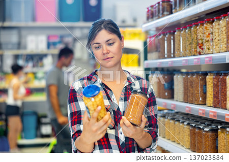 Young woman choosing preserved food in supermarket 137023884