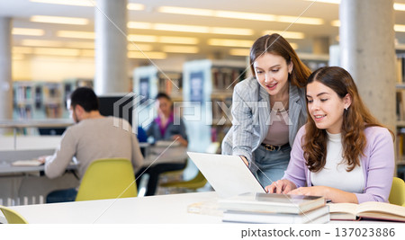 Two woman students, preparing a report on a laptop Two woman students, preparing a report on a laptop 137023886