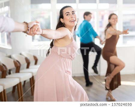 Young brunette practicing swing with partner in choreographic studio Young brunette practicing swing with partner in choreographic studio 137024030