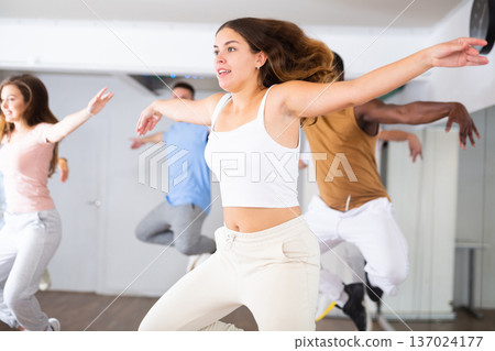 Females and males doing dance workout during group classes in fitness center 137024177