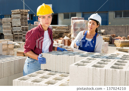 Manager instructs worker how to lay cinder blocks Manager instructs worker how to lay cinder blocks 137024210