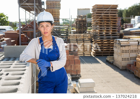 Female builder in outdoor material storage 137024218