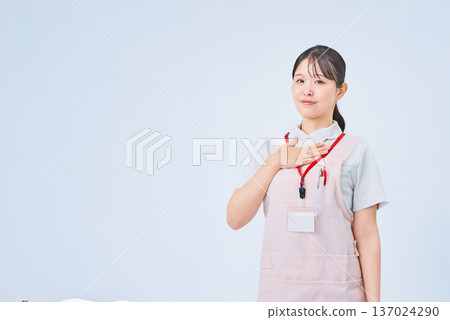 A woman in a white coat with her hand on her chest 137024290
