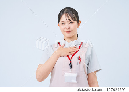 A woman in a white coat with her hand on her chest A woman in a white coat with her hand on her chest 137024291