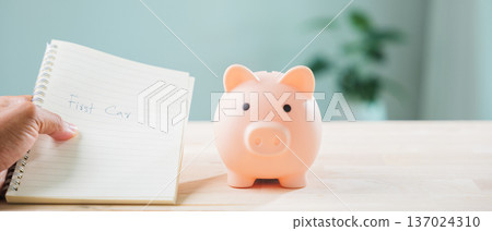 Planning first car savings using piggy bank and money, person holding notebook with life goal to manage cost for insurance tax and loan, starting saving journey for buying vehicle Planning first car savings using piggy bank and money, person holding notebook with life goal to manage cost for insurance tax and loan, starting saving journey for buying vehicle 137024310