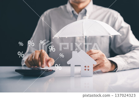 Protect your house and finance with an umbrella, keeping it safe from rates, showing investment and a lover concept, the property is really well insured if you are insured Protect your house and finance with an umbrella, keeping it safe from rates, showing investment and a lover concept, the property is really well insured if you are insured 137024323