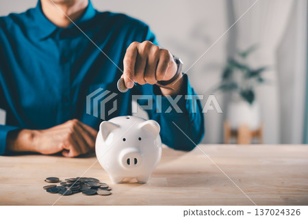 Global economy money bank piggy finance stock growth business concept shows man putting coin into ceramic bank to save for future, economic success requires long term invest goals Global economy money bank piggy finance stock growth business concept shows man putting coin into ceramic bank to save for future, economic success requires long term invest goals 137024326