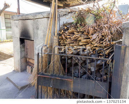 Everyday scenes at the temple: a well-used outdoor incinerator and bamboo brooms 137025134