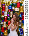 Woman portrait in front of colorful holiday jewel wall decoration 137025599