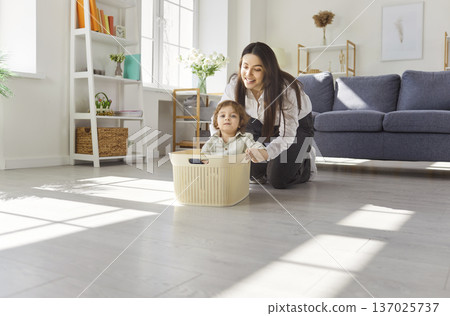 Happy mother playing with child in bright living room, bonding at home Happy mother playing with child in bright living room, bonding at home 137025737
