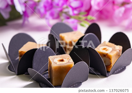 Butter caramel fudge squares with hazelnuts and wisteria. 137026075