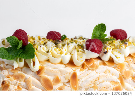 Meringue cream cheese roll with raspberries, mint and nuts. Meringue cream cheese roll with raspberries, mint and nuts. 137026084