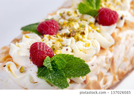 Meringue cream cheese roll with raspberries, mint and nuts. Meringue cream cheese roll with raspberries, mint and nuts. 137026085