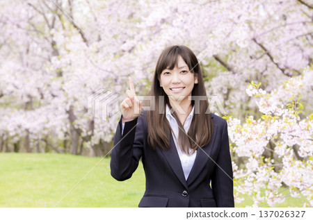 一位OL在櫻花樹前舉起食指 137026327