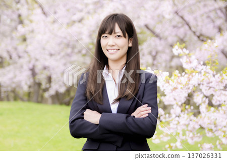 Office lady with her arms crossed in front of the cherry blossoms 137026331