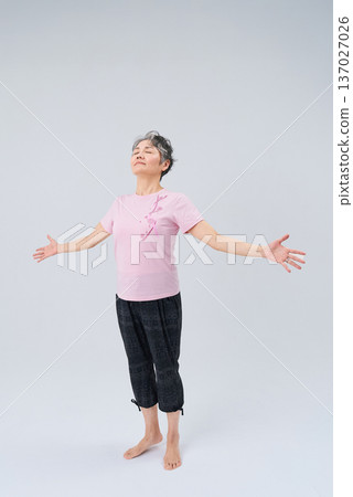 Senior woman wearing sportswear taking a deep breath Senior woman wearing sportswear taking a deep breath 137027026