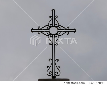 Serene portrayal of faithinspired iron craftsmanship silhouetted against cloudy sky background Serene portrayal of faithinspired iron craftsmanship silhouetted against cloudy sky background 137027093