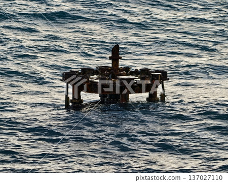 Abandoned maritime ruin, Desolate steel structure drifting on rough seas with barnacles and peeling paint Abandoned maritime ruin, Desolate steel structure drifting on rough seas with barnacles and peeling paint 137027110