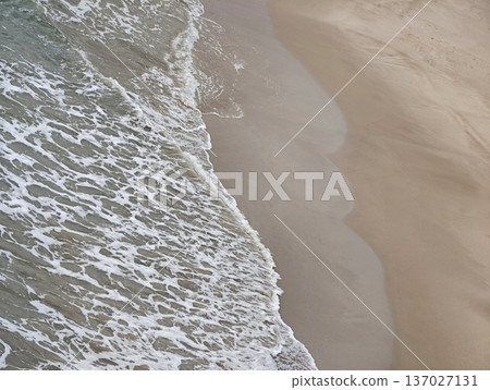 Undulating shoreline crashing amid tranquil scene, Flowing coast with foamy waves in dynamic harmony Undulating shoreline crashing amid tranquil scene, Flowing coast with foamy waves in dynamic harmony 137027131