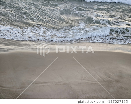Vast quiet shoreline, Expansive barren sands featuring distant undulating sea waves and soft rippling patterns 137027135