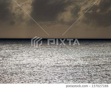Reflective silver ocean beneath storm clouds with cinematic lighting for branding and technological visuals 137027166