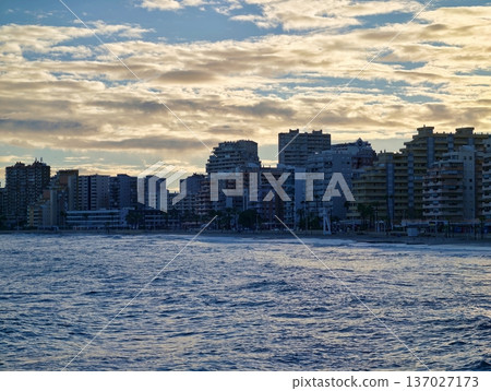 Peaceful seaside cityscape at dawn, Tranquil waterfront with vibrant morning activity and scenic views Peaceful seaside cityscape at dawn, Tranquil waterfront with vibrant morning activity and scenic views 137027173