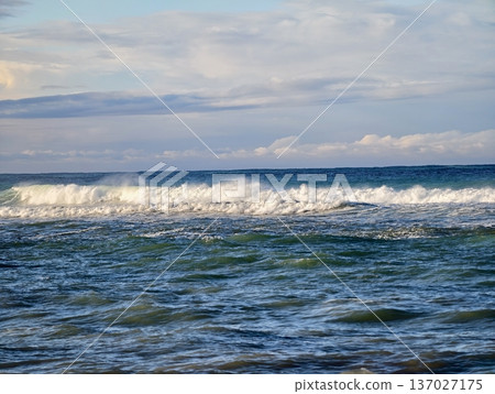 Calm sea meeting cloudy sky above, Tranquil waters with ripples and distant whitecaps observed Calm sea meeting cloudy sky above, Tranquil waters with ripples and distant whitecaps observed 137027175