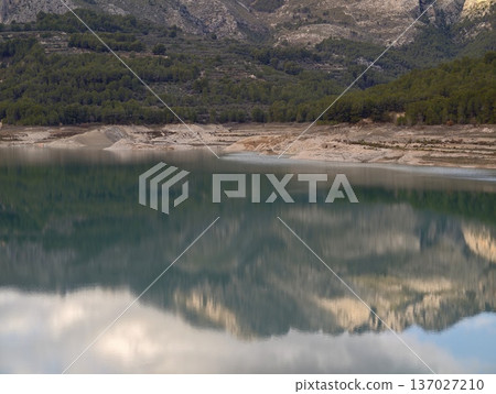Dawn mountain reflection, Early morning scenery featuring peaceful lake and towering rocky summits Dawn mountain reflection, Early morning scenery featuring peaceful lake and towering rocky summits 137027210