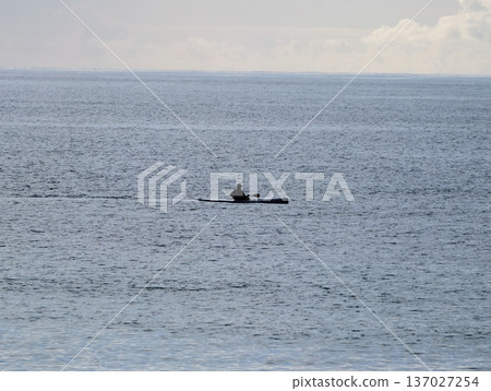 Serene ocean journey at sunrise captured, Calm solitary boat adventure amidst gentle morning mist 137027254