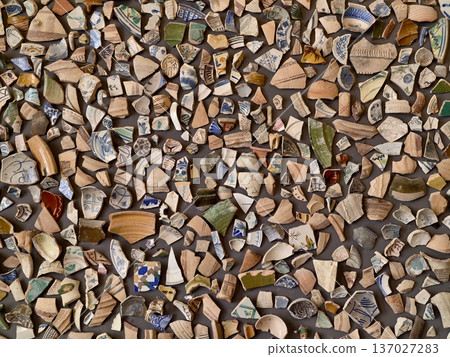 Vivid ceramic fragments arranged in intricate pattern with contrasting colors and textures 137027283