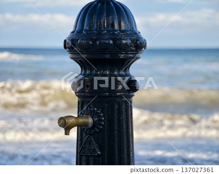 Oldfashioned metal water pump adorned with brass fittings evoking maritime tradition and travel lifestyle Oldfashioned metal water pump adorned with brass fittings evoking maritime tradition and travel lifestyle 137027361