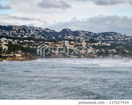 Stormy coastal scenery, Rough seas meet hillside residences amidst morning fog embodying strength and serenity Stormy coastal scenery, Rough seas meet hillside residences amidst morning fog embodying strength and serenity 137027434