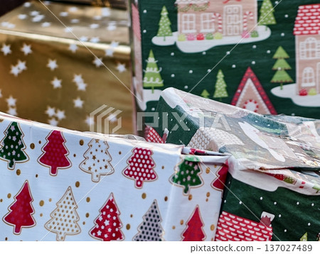 Decorative packages with holiday accents, Family organizing gift surprises in cozy holiday setting 137027489