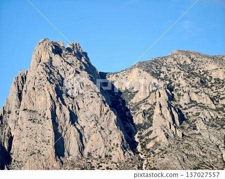 Imposing natural stone face with sharp ridge and glowing sky providing dramatic training scenery Imposing natural stone face with sharp ridge and glowing sky providing dramatic training scenery 137027557
