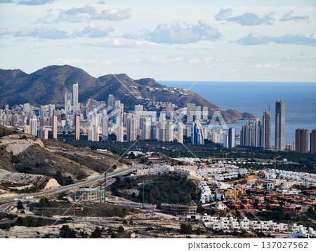 Cityscape with mountains and water, Vertical city growth rising against rocky terrains by waterfront Cityscape with mountains and water, Vertical city growth rising against rocky terrains by waterfront 137027562