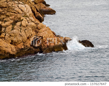Calm waves lapping warmcolored stones gently, Gentle surf caressing sunlit rocks with calming ripples Calm waves lapping warmcolored stones gently, Gentle surf caressing sunlit rocks with calming ripples 137027647