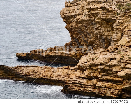 Jagged stone terraces bordered by tumultuous surf and intricate geological formations suitable for study Jagged stone terraces bordered by tumultuous surf and intricate geological formations suitable for study 137027670
