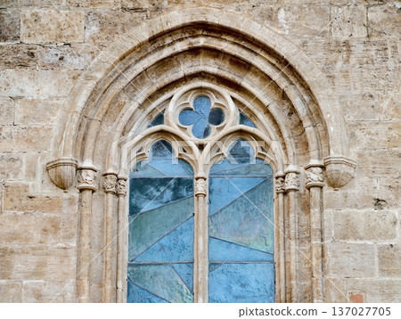 Gothic facade exhibits detailed tracery with patinated stone and vibrant stained glass panes Gothic facade exhibits detailed tracery with patinated stone and vibrant stained glass panes 137027705