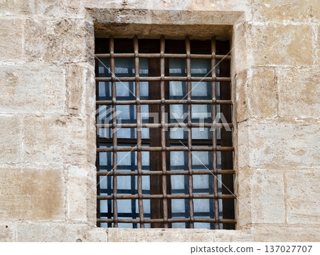 Industrial style window with reflections, Stoneframed window featuring reflective glass and iron bars 137027707