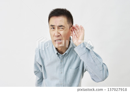 A man who is hard of hearing on a white background A man who is hard of hearing on a white background 137027918