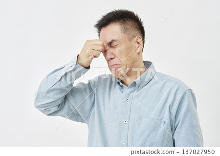 一個男人在白色背景前摀著眼睛 137027950