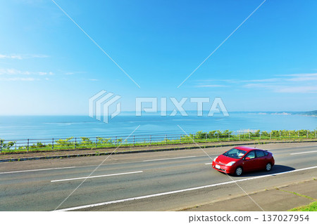 北海道：行駛在藍天和海邊公路上的汽車 137027954