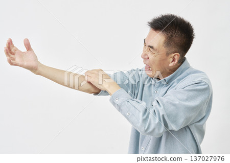 A man scratching his arm on a white background A man scratching his arm on a white background 137027976