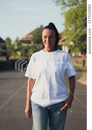 Smiling Mature Scandinavian Tourist Woman Walking Outdoors on Summer Holiday 137028993